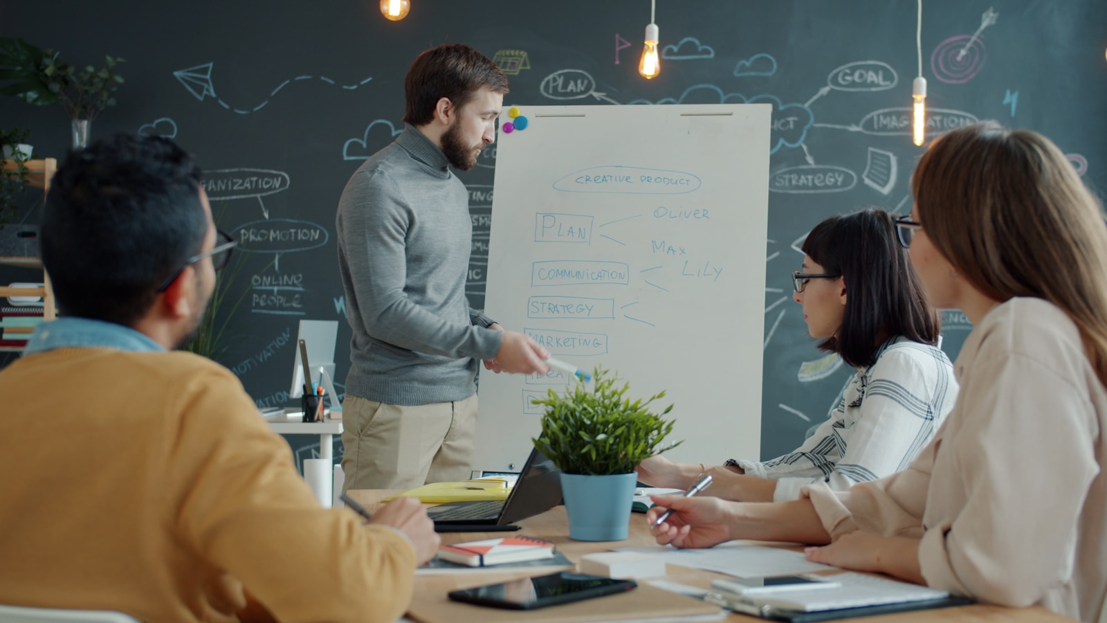 Team collaborating around a whiteboard in a modern office.